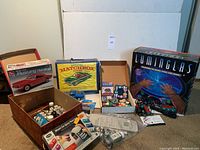 Full lot view showing 1966 Ford Mustang model kit box, Matchbox collector case, assorted magnets in container, Luminglas light box, Glow FX lights, and Hot Wheels Jeep box.