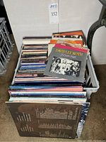 Crate filled with vinyl albums, singles and CD box on top