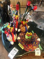 Overview of all four glass clown pieces arranged on marble surface