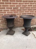 Frontal view of both urns side by side against brick wall