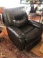 Front and angled view showing the chair's plush padded seating, armrests, and recliner lever.