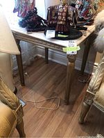 Full view of the side table showing marble top and gold-finished legs with decorative carvings.