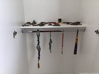 Closet interior showing hanging tassel necklaces and shelf with chain necklaces and pendants
