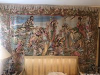 Full wall view of tapestry hung above couch with top fringe visible