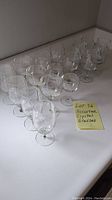 Angle view showing all 15 assorted crystal glasses grouped on a white surface