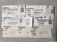 Photo showing seven envelopes with handwritten labels indicating Canadian Confederation stamp catalog numbers and approximate counts of stamps in each envelope.