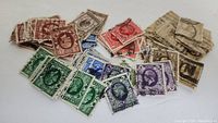 Pile of assorted King George V stamps in various colors and denominations, mostly used with visible postmarks.
