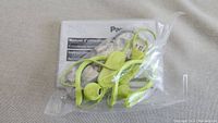 Green Panasonic Bluetooth stereo earphones sealed in plastic with manual visible inside.