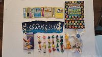Photo showing the trading cards, mini-figures, and Pokemon Deluxe Essential Handbook laid out on a brown surface.