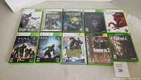Top view of all 10 Xbox and Xbox 360 games cases showing cover art for titles including Bioshock, Skyrim, Fallout 4, Halo Reach, Halo 4, Dragon Age Origins, and others.