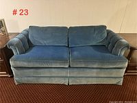Front view of the royal blue velvet loveseat with loose cushions and rounded arms