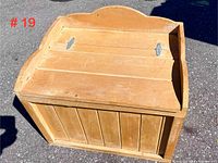 Photo of the top and front of the solid pine chest showing the hinged lid and natural finish with curved top edge.