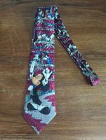Full length image of the Disney tie showing character artwork front side with Mickey and Goofy visible on a maroon patterned background.