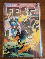Front cover image showing Captain America and Ghost Rider fighting against reaper-like antagonist with fire background.