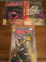 Three Batman comics including Blue Beetle Psyba-Rats Arkham, Arkham Asylum Tales of Madness, and Detective Comics Batman.