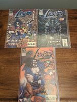 Three comics from the Lobo series (#2, #3, #4) from DC Comics, all bagged in plastic sleeves, laid flat showing full covers.