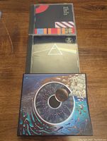 Front view of three Pink Floyd CD jewel cases stacked vertically showing album cover art: The Final Cut (top), Dark Side of the Moon (middle), Pulse (bottom).