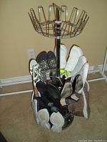 Full view of 11 pairs of ladies shoes arranged on a metal rotating shoe rack, showing shoes in vertical clips with various colors and types.