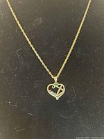 Gold-tone heart pendant necklace on black background