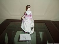 Front view of the Royal Doulton Good Companion porcelain figurine showing a young woman in a pink and white dress with a black and white dog.