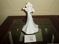 Front view of Royal Doulton Olivia porcelain figurine showing woman in long flowing dress and hat.