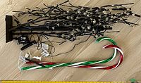 The full set of items including the lighted artificial tree with black branches and rectangular base, and the two large LED candy cane lights in red/white and green/white colors, with cords visible.