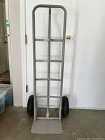 Front view of the Hausmann dolly showing its tall steel tube frame, handle, and inflatable wheels.