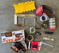 Full lot of assorted woodworking tools including power and hand tools arranged on concrete floor.
