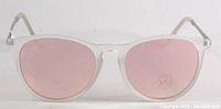 Front view of sunglasses showing pink Revo lenses and frosted clear frames.