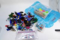 Overview of mixed toy parts including transformers, figurines, and bracelet kit