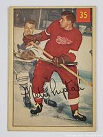 Front image of 1954-55 Parkhurst Metro Prystal hockey card showing Detroit Red Wings player wearing red uniform on ice with card number 35 and facsimile signature.