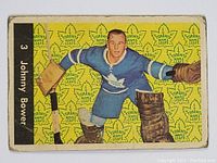 Front of 1961-62 Parkhurst Johnny Bower hockey card showing player image on yellow backdrop with Maple Leafs logos.