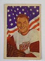 Front of 1963-64 Parkhurst hockey card showing Vic Stasiuk in Detroit Red Wings uniform with American flag background.