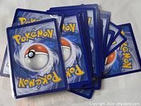 Photo showing the backs of Pokemon trading cards in a stacked arrangement.