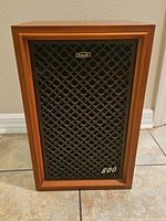 Full front view of the Coral BX-800 speaker showing wooden cabinet and black patterned grill with logo and model number.