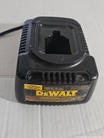 Top view of black DeWalt DW9116 battery charger showing the slot for 18V battery insertion and DeWalt branding label on front.