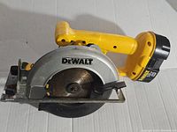 Full side profile showing the yellow handle, battery attachment, silver blade cover with DeWalt logo, and circular saw blade.