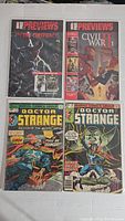 Four comic books shown including The New Previews: The Hood Conspiracy #1, The New Previews: Civil War #1, and two Doctor Strange issues.
