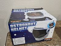 Box showing front graphics and product name 'Astronaut Helmet' with image of helmet and child wearing it.
