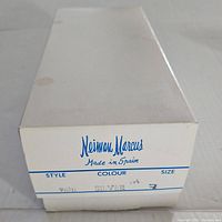 White Neiman Marcus shoe box with style, color and size label indicating silver color and size 7