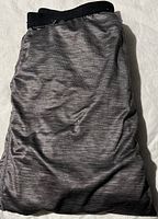 Folded gray athletic pants showing texture and waistband