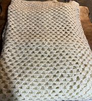 Photo of a cream colour knitted throw showing the diamond pattern texture.