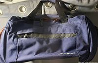 Navy blue duffle bag with black handles, front zipper pocket and Eddie Bauer logo embroidered on front