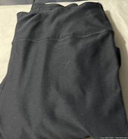 Folded black pants showing smooth fabric texture.