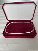 Full view of the sterling silver necklace displayed in a red velvet jewelry box.