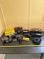 Full overview of all items on table including bag, projectors, cameras, slide trays and accessories