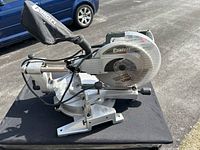 Side view of Concept sliding compound miter saw showing blade, dust bag, and base.