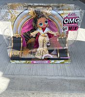 Full front view of the doll in its original collector edition packaging showing the doll, backdrop, and branding.
