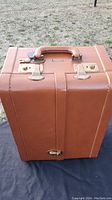 Exterior front of brown bar case showing handle, latches, lock