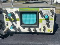 Front view showing MeterMaster oscilloscope model, control knobs, screen, and input connectors.